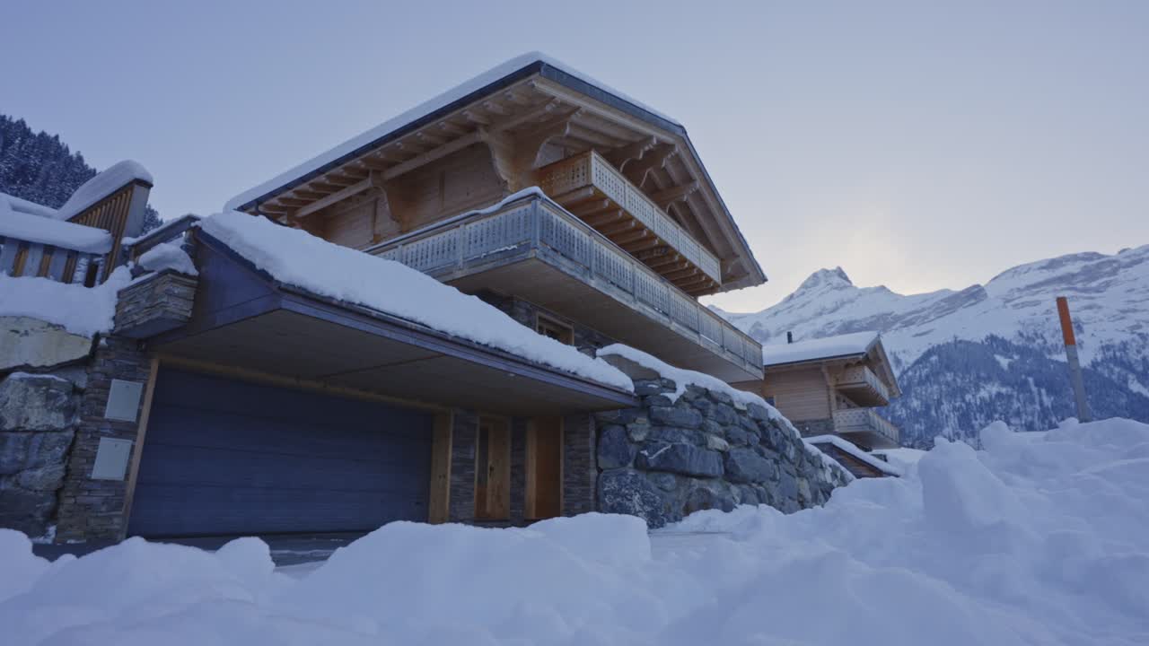 dolly de bajo ángulo de un hermoso chalet de madera cubierto de nieve en un día de invierno temprano