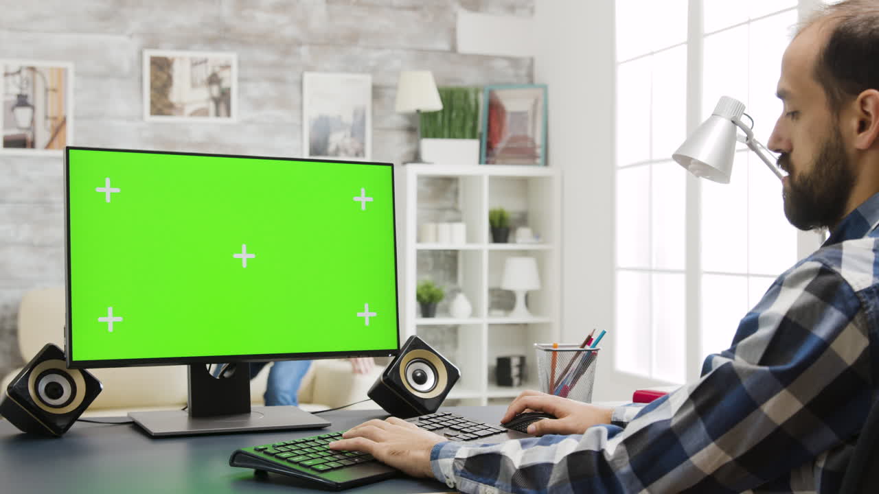 hombre trabajando en la computadora con pantalla verde