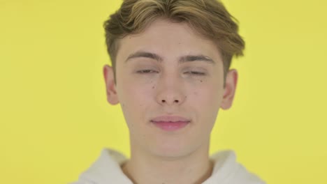 close up of shocked young man, yellow background