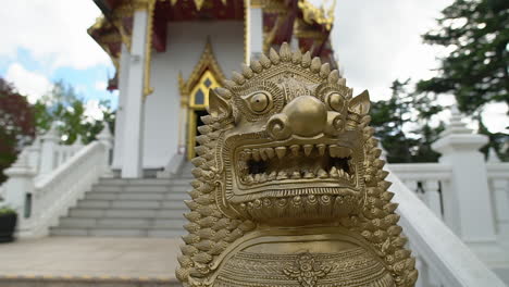 一座石頭獅子雕像站在隱藏的泰國佛教寺<unk>前