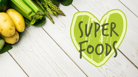 animation of super foods text in green over fresh organic vegetables on wooden boards