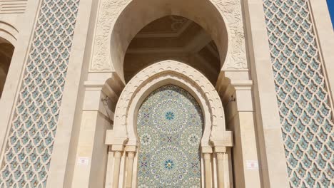 Looking-down-majestic-Hassan-ii-mosque-marble-tower-to-decorative-Arabic-patterned-mosaic-fountain