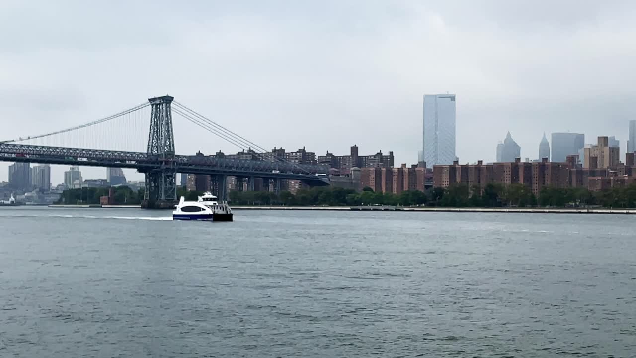 Manhattan New York City East River Ferry approaching to Brooklyn North Williamsburg Terminal underneath Williamsburg Bridge on a hazy day