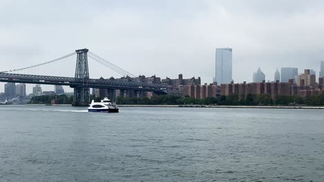 manhattan new york city east river ferry approaching to brooklyn north williamsburg terminal underneath williamsburg bridge on a hazy day