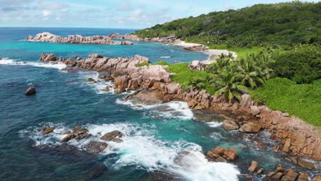 vista aérea de las olas rompiendo en la costa despoblada de anse songe en la digue, una isla de las seychelles