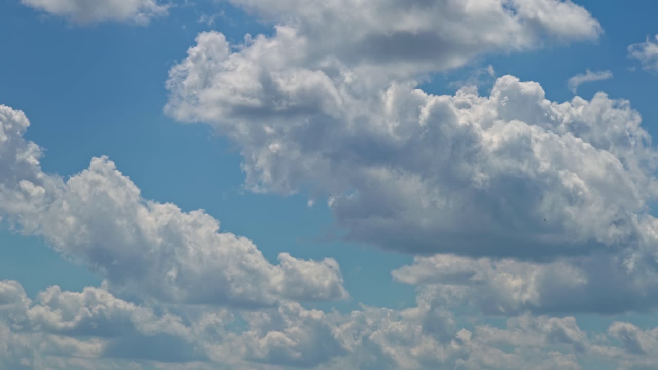 Clouds drift across the blue sky during the afternoon in summer