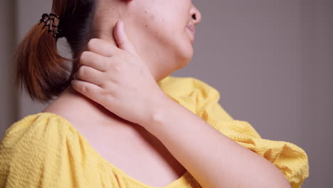 close-up shot of a woman massaging her nape using her hands and fingers to relieve the tension and stress that she is feeling