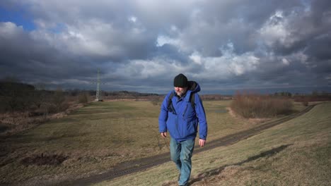 tourist man and dog walking uphill in nature, happy thumbs up gesture