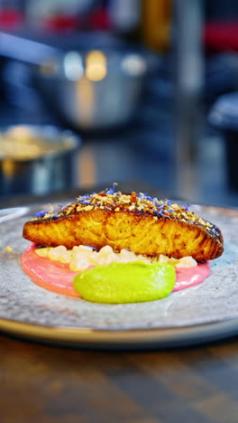 serving cooked piece of fish beautifully. salmon with two sauces and spices on top. close up. vertical video.