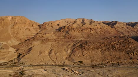 aerial pan shot of red mountain ridge of judea desert israel, clear sky day