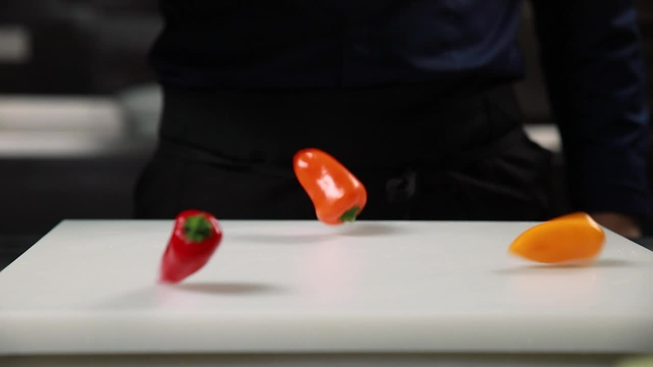 шеф-повар готовит перцы на доске для резки