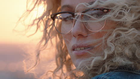 close up portrait of beautiful blonde woman looking confident enjoying relaxed vacation lifestyle feeling freedom on seaside at sunset