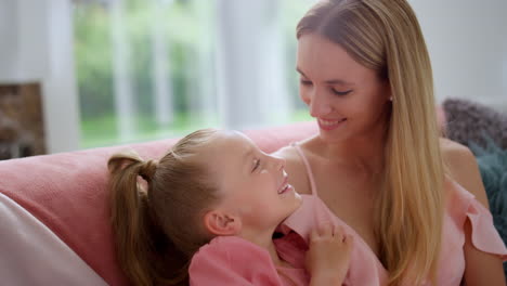 cute girl and happy mother touching noses. smiling woman playing with daughter