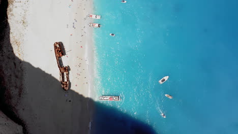 Aerial:-Rising-top-down-shot-of-the-Navagio-beach-with-the-famous-wrecked-ship-in-Zakynthos,-Greece