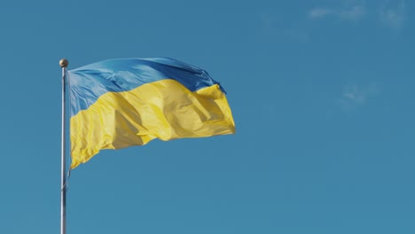 Ukraine-flag-on-a-pole-in-blue-sky-background