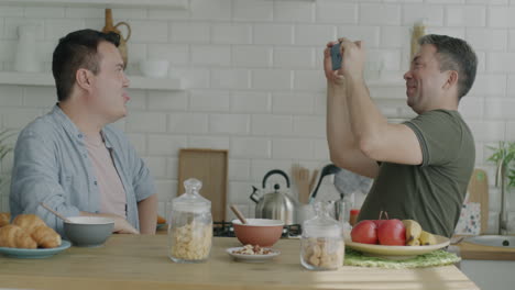 two men enjoying breakfast together in kitchen