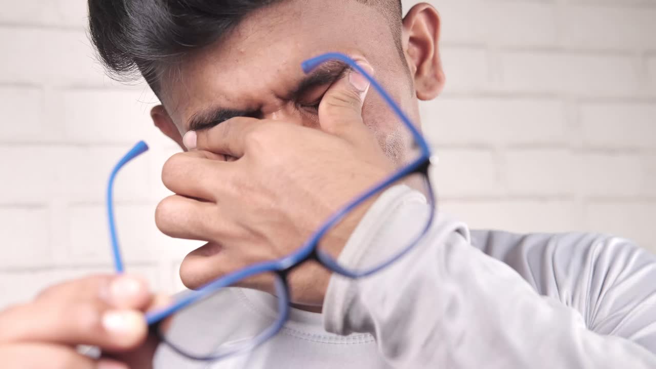 hombre que experimenta fatiga ocular e incomodidad por las gafas