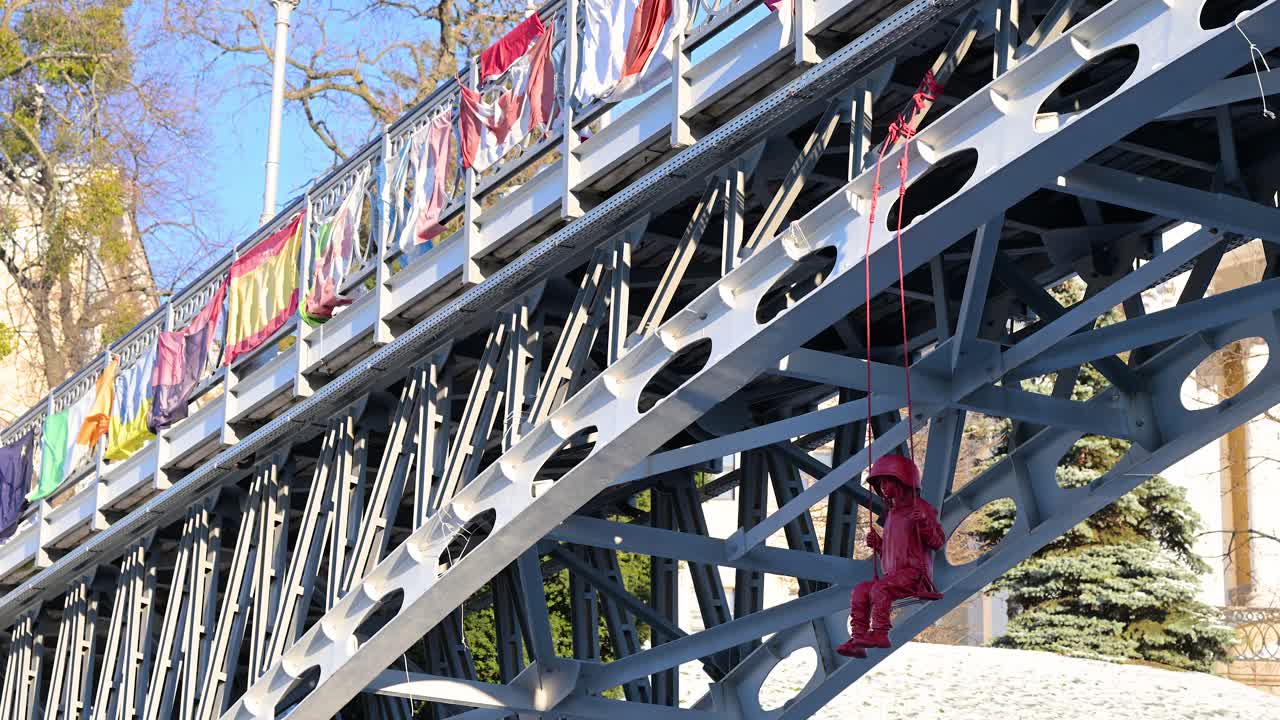 James Colomina’s "Swing" sculpture in Kyiv features a girl in a large military helmet on a swing under a bridge near the Alley of Heroes, close to Independence Square (Maidan Nezalezhnosti), Ukraine.