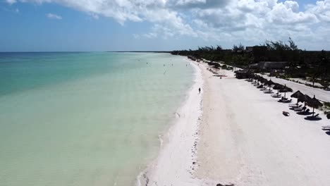 Luftaufnahme-Einer-Flachen-Strandküste-Mit-Strandhütten-Palapas