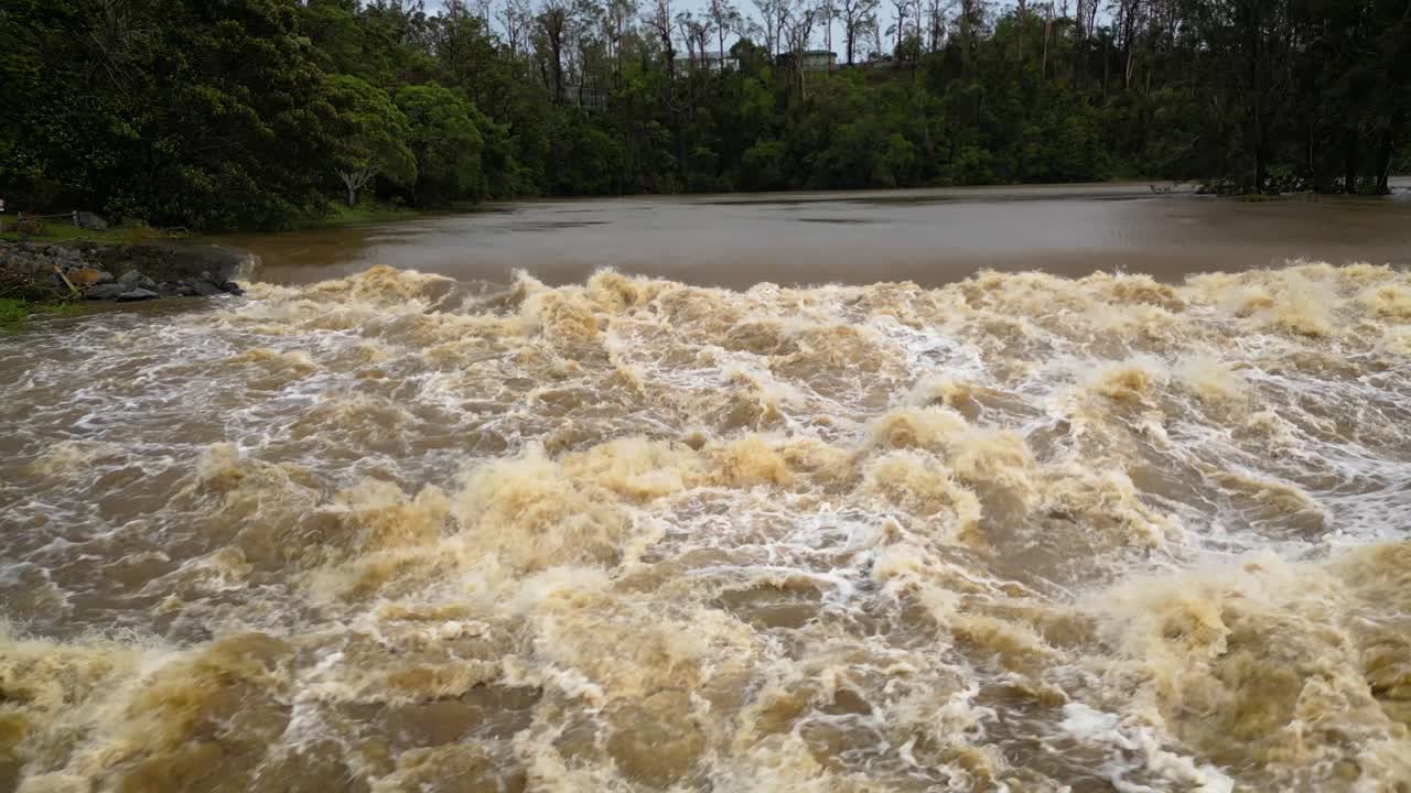 Coomera, Gold Coast, 2 January 2024 - Left to right low angle aerial view of Coomera River Causeway under flood waters from the 2024 Storms in January