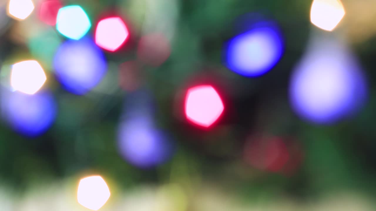 las luces multicolores de navidad parpadean hermosamente fuera de foco.