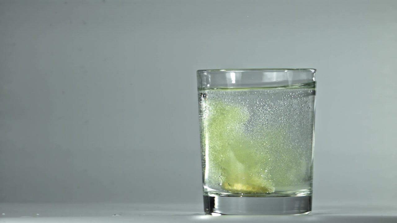 Compressa effervescente che si dissolve in un bicchiere d'acqua con bollicine