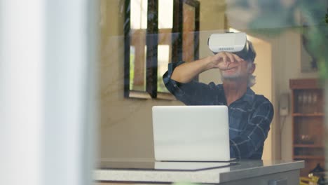 Senior-man-using-virtual-reality-headset-in-kitchen-4k