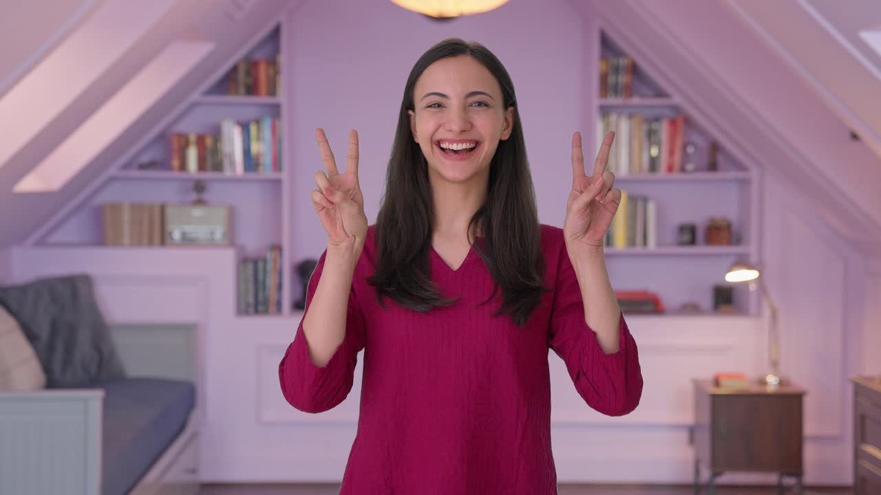 행복한 인디언 소녀가 승리의 표시를 보여주고 있습니다.