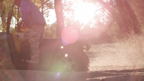 quad bike start in slow motion. man on atv starting with dust at sand road