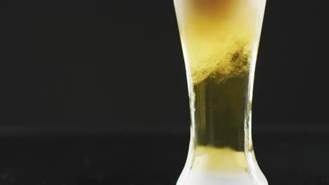 Video-of-glass-of-beer-with-foam-on-black-background
