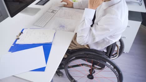 man sitting in wheelchair, wheelchair man in corporate office.