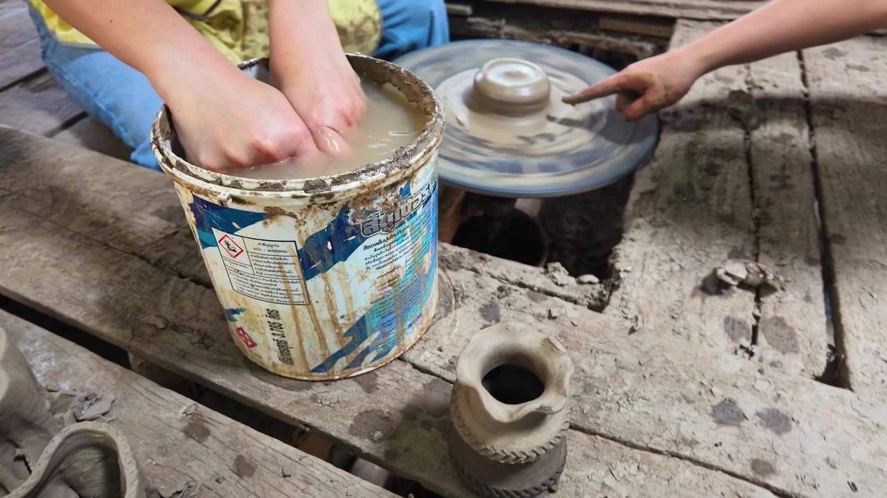 Primo piano delle mani di un vasaio che modellano argilla umida su un tornio a Nonthaburi, Thailandia