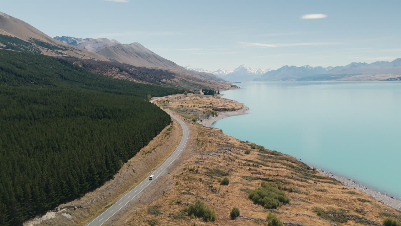 Aerial View of a Scenic Road by a Turquoise Lake in New Zealand Mountains