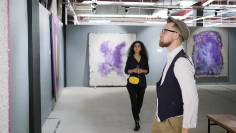 pareja viendo arte abstracto en una galería de arte