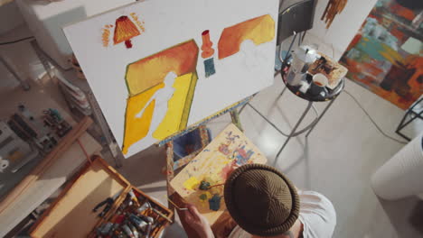 High-Angle-of-Artist-Painting-Picture-in-Studio