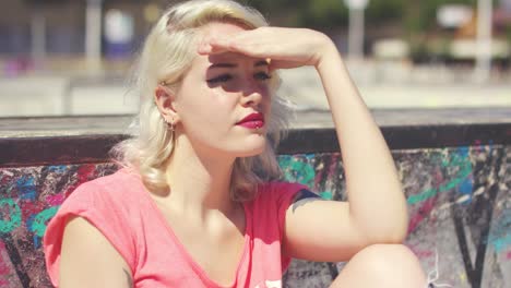 young woman with a tattoo looking in to the sun