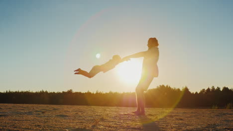 Gesunder-Vater,-Der-Bei-Sonnenuntergang-Mit-Seinem-Sohn-Spielt---Umkreist-Es-Schöne-Runde-Blendung-Der-Sonne-In-Th