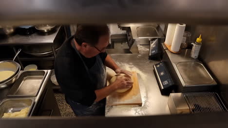 chef kneading dough in a commercial kitchen