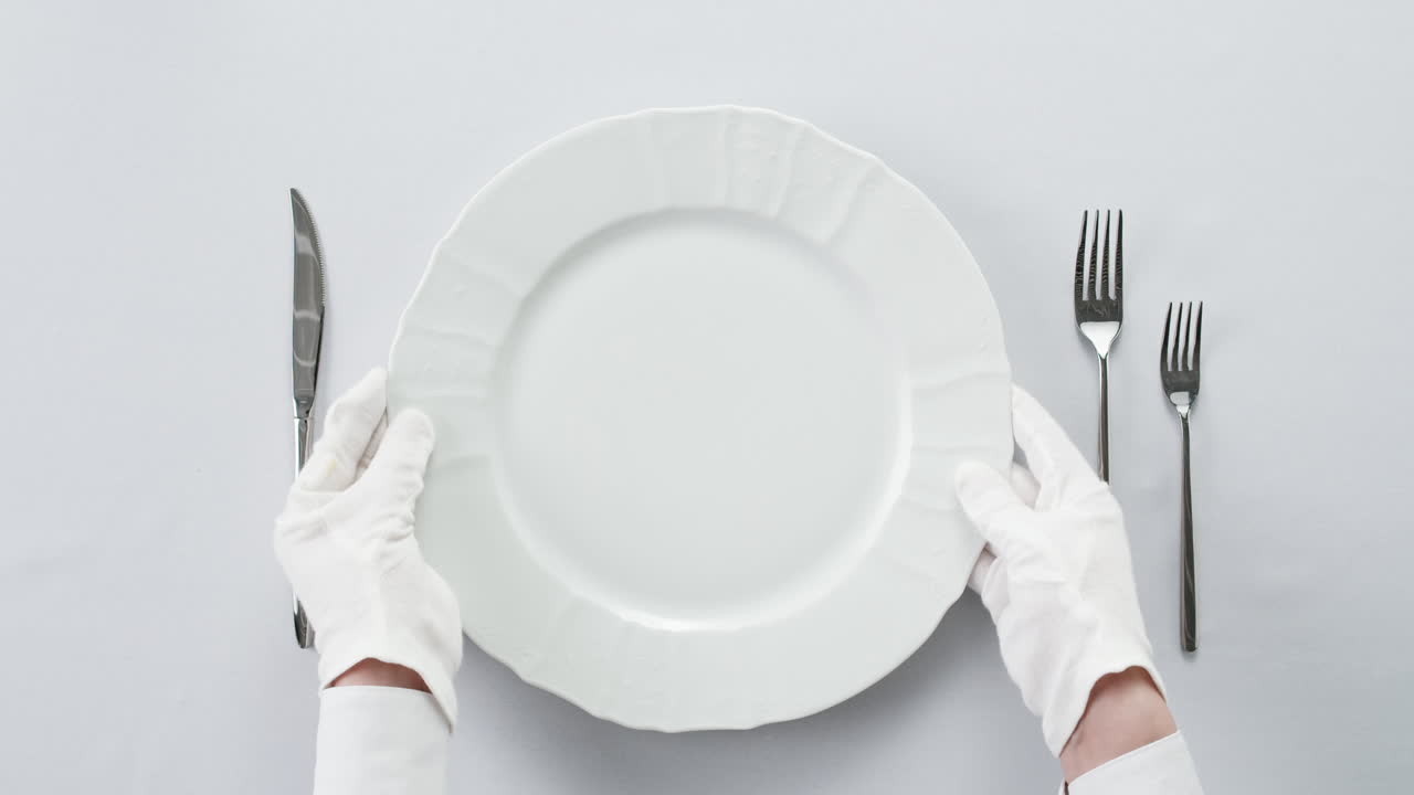 Empty plate with cutlery and gloves