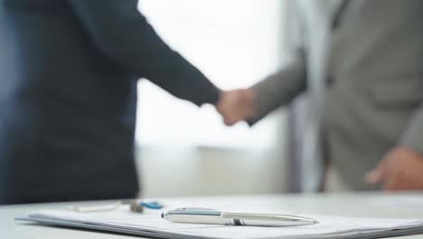 close up pen put on the desk on the two businessman hands shake background.4k resolution.