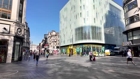 a bustling urban street scene in london with pedestrians and police vehicles.
