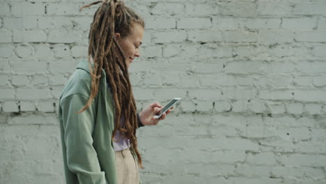woman with dreadlocks using a smartphone outdoors