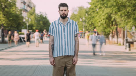 man in a striped shirt and shorts on a city street