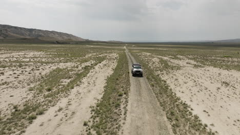 jeep conduciendo por un camino de tierra en la árida llanura de estepa vashlovani en georgia
