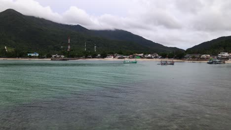 una foto de un dron de botes de cola larga en el agua turquesa en la playa de malibu, isla de koh phangan, tailandia
