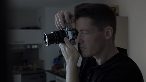 close-up shot of a photographer looking down the viewfinder at his subject