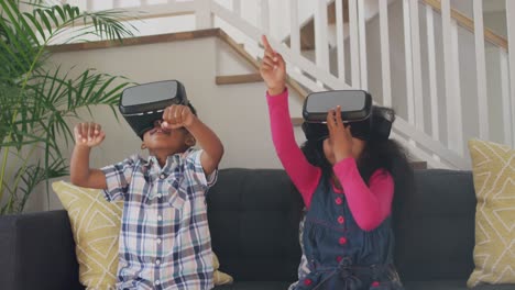 african american siblings wearing vr headsets and having fun