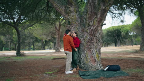 couple standing leaning tree hugging. cute pair talking cuddling on nature park.