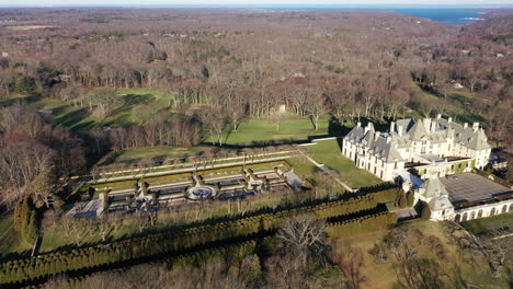 an aerial view over a large, upscale, luxury mansion with an eight reflection pool fountain, on long island, ny