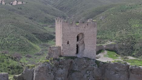 flight-in-reverse-visualizing-the-castle-of-Oreja-9th-century-we-see-a-deterioration-in-the-tower,-moving-away-we-contemplate-the-spectacular-situation-of-the-castle-in-ravines-Ontigola-Toledo-Spain